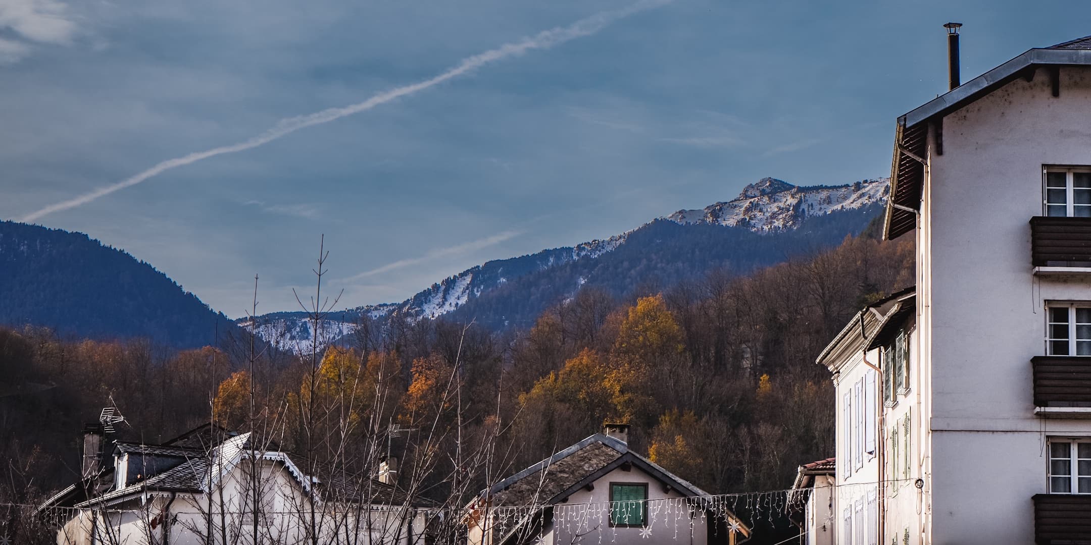 Village houses beneath snow-covered mountains photographed by Eugene Truuts