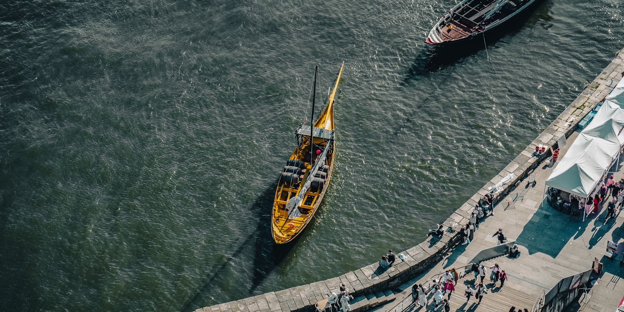 Traditional boat approaching a riverside quay in Porto, Portugal photographed by Eugene Truuts
